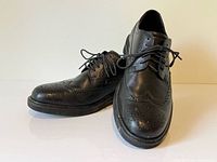 overall view of both black leather wingtip brogue shoes