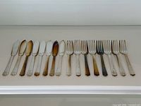 Full view of eight fish knives and eight fish forks lined up