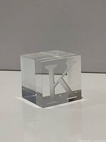 Full view of crystal cube paperweight showing etched K