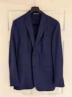 Front view of navy blazer on hanger showing style and condition