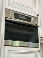 Front view of stainless steel Miele built-in convection steam oven installed in cabinetry