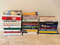 Three stacks of assorted non-fiction books showing quantity and general condition
