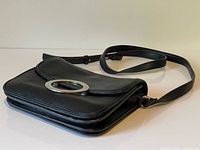 Full view of black pebbled faux-leather crossbody bag with strap