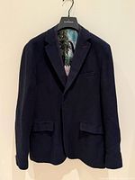 Front view of dark blue Ted Baker blazer on hanger, showing lapel, pockets and glimpse of scenic lining