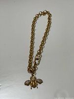 Full view of gold-tone chain link necklace with bee charm