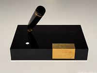 Full view of black acrylic Montblanc pen stand with cap section inserted at angle