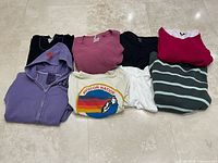 All eight folded tops laid out on floor