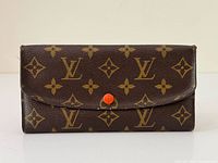 Front view showing LV monogram canvas and orange snap button