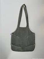 Full view of grey silk Armani purse hanging