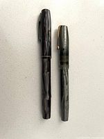 Both closed pens side by side showing size, color variation, overall condition