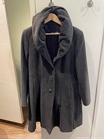 Full front view of dark grey wool coat on hanger