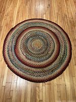 Full view of round braided rug on hardwood floor