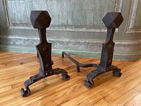 Pair of hand forged andirons, front view highlighting faceted finials and scroll feet