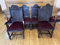 Front view of five oak dining chairs, one with arms