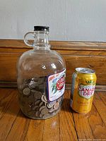 Full view of jug filled with pennies, Canada Dry can shown for scale