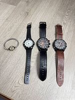 Four watches laid out side-by-side showing overall design and straps