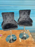 Pair of black velvet adjustable barstools with chrome bases