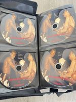 Open binder displaying four numbered Muhammad Ali match DVDs with printed labels