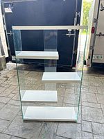 Full front view of glass and white wood shelving unit