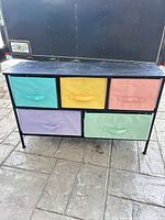 Front view showing five pastel fabric drawers and metal frame