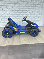 Left side view of blue and black ride-on go-kart with Speed decal