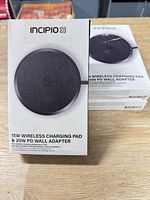 Front of boxed Incipio wireless charging pad set, three additional boxed sets stacked