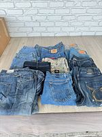 Entire lot of folded denim jeans and shorts on table
