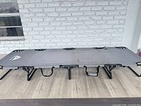 Full view of gray Ozark Trail folding cot unfolded on floor