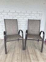 Front view of two matching metal patio chairs