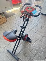 Full view of the foldable exercise bike showing handlebars, console, seat, frame and bands