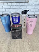 Group shot showing all five items: three metallic tumblers, Friends bottle, boxed wine tumbler