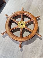 top view of entire wooden ship steering wheel showing brass hub and overall wear