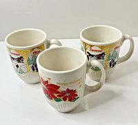 Three Syracuse China holiday mugs, front view showing graphics