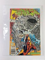 Front cover showing Hulk and Spider-Man battle, bagged with board