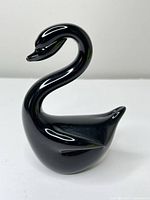 Front profile of black glass swan figurine showing overall form