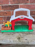 Front view of Fisher-Price Little People barn stable showing missing doors and attached side platform