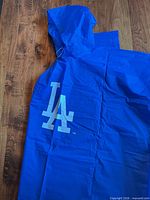 Full view of blue poncho showing LA logo and hood