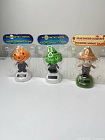 Front view of three sealed solar dancing figures