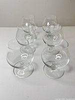 Six clear brandy glasses front view
