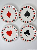 Four Luminarc plates showing each suit design