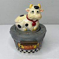 Front view of mechanical timer with cow figure and Sweet Home plaque