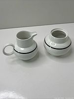 front view of creamer and sugar bowl showing shape and band