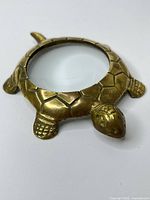 Top view of brass turtle magnifier showing full design and glass lens