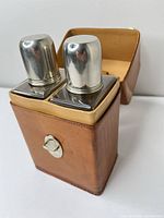 Front view of leather case with both metal-topped flasks inside