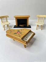 Group shot of two chairs, piano, fireplace