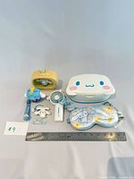Group shot of accessories including fan, tissue case, eye mask, keychain items