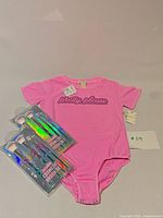 Bodysuit with graphic text and two packaged brush sets