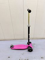 Full side view of pink Kickboard scooter showing three wheels and adjustable handlebar