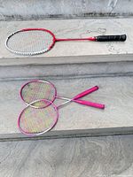 All three badminton rackets displayed on stone steps