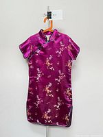 Front view of magenta floral satin qipao dress on hanger